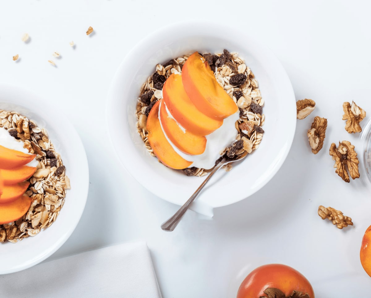 Bol de muesli avec yaourt végétal et fruits frais coupé en tranche pour un petit-déjeuner équilibré