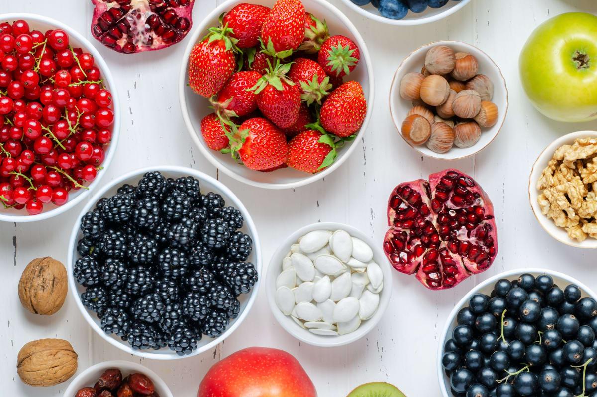 Exemples d'aliments riches en fibres pour le petit-déjeuner, comme des fraises, des noisettes et des fruits rouges
