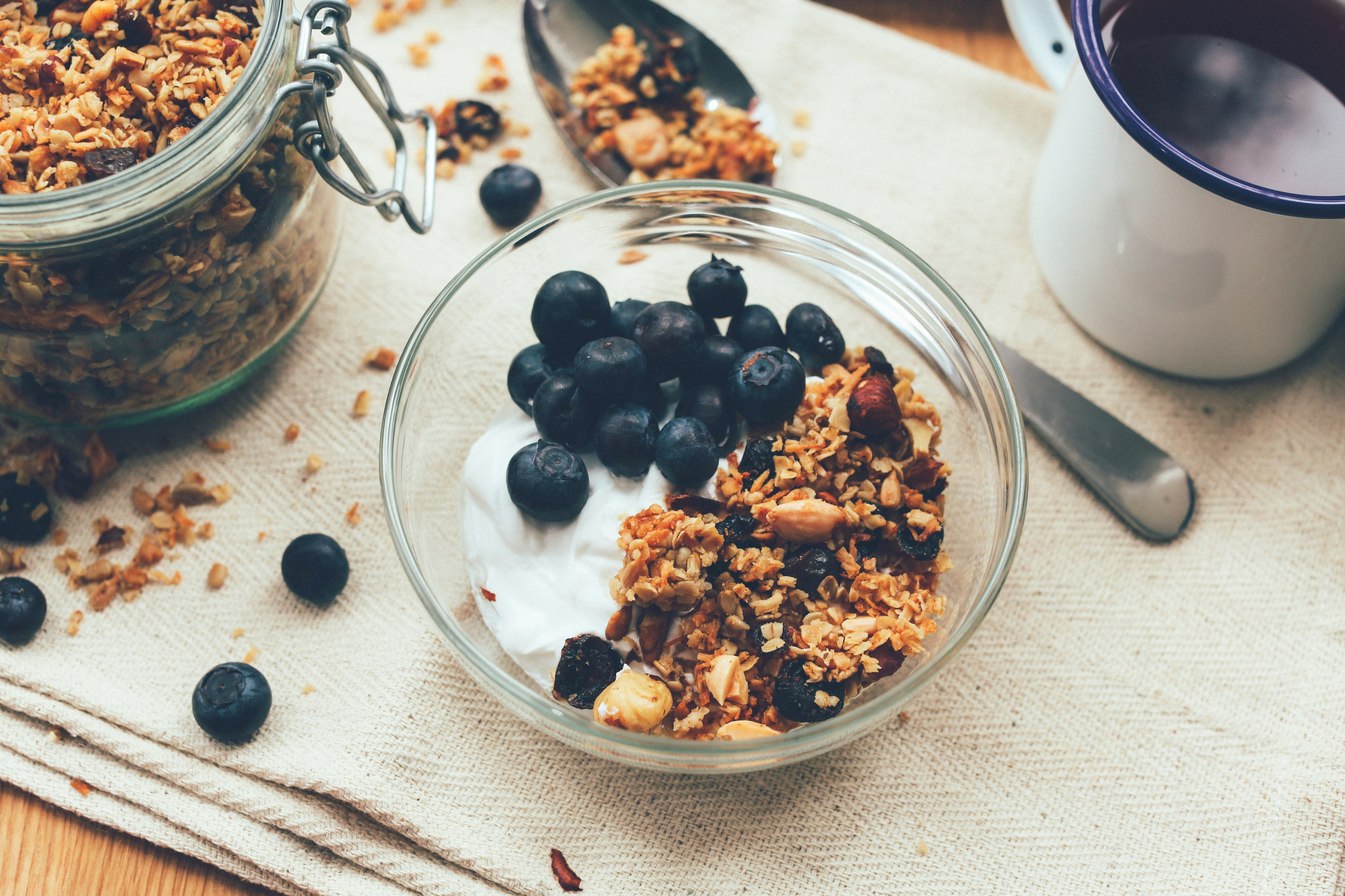 Gros plans sur un bol de granola pour le petit-déjeuner, avec des myrtilles et du yaourt