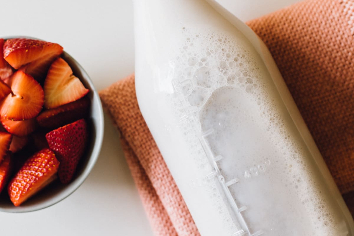 Bouteille de kéfir de lait et fraises coupées en morceaux sur une table