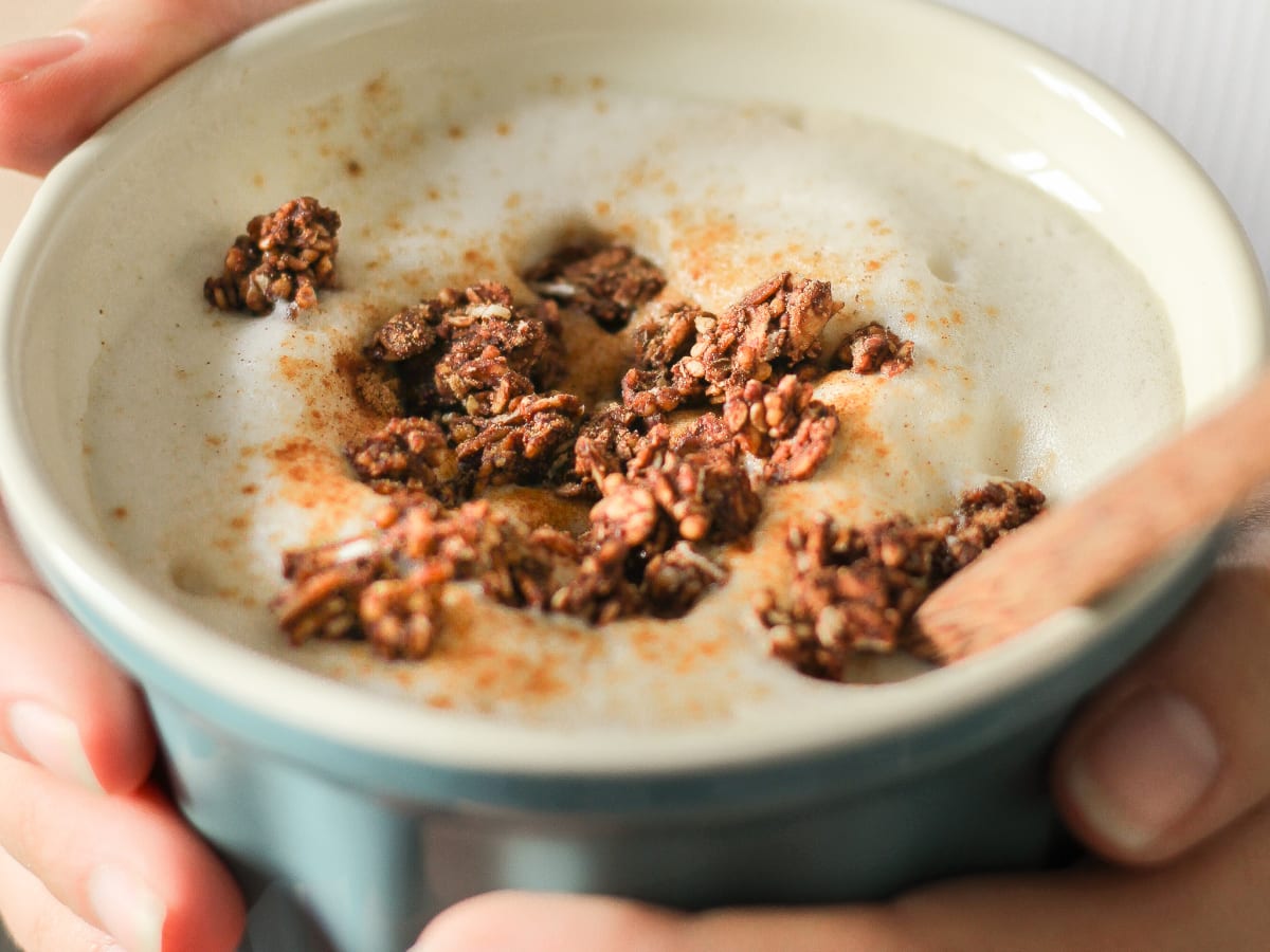 Gros plan sur un oatmeal latte avec des pépites de granola à la surface