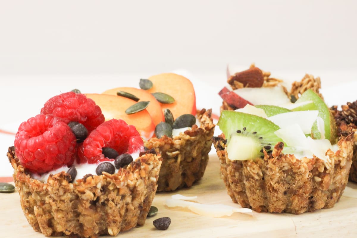 Trois tartelettes sans gluten et véganes garnies de kiwi, framboises et tranches de pomme