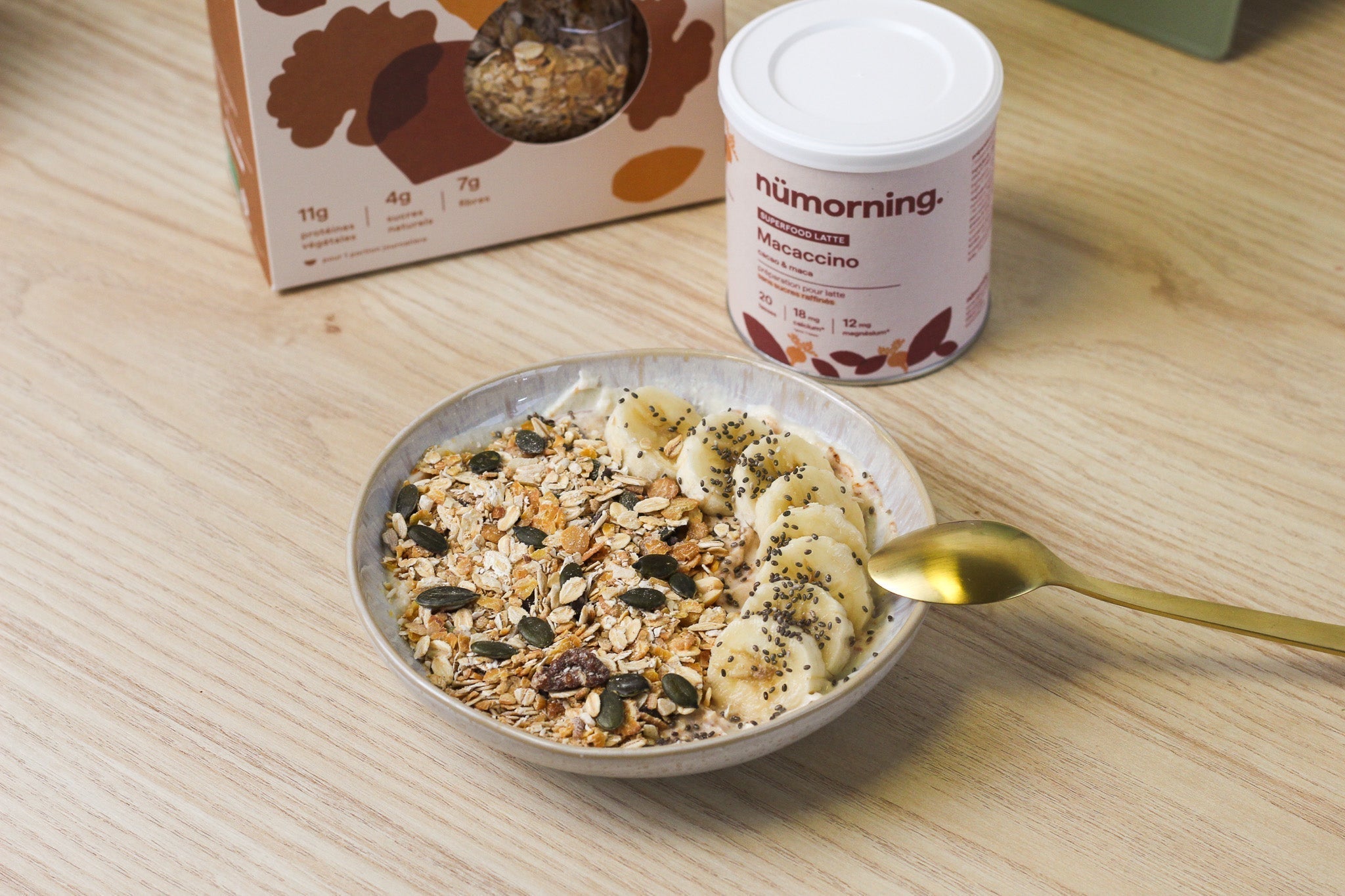 Gros plan sur un muesli bowl à la banane et au beurre de cacahuète avec une cuillère dorée