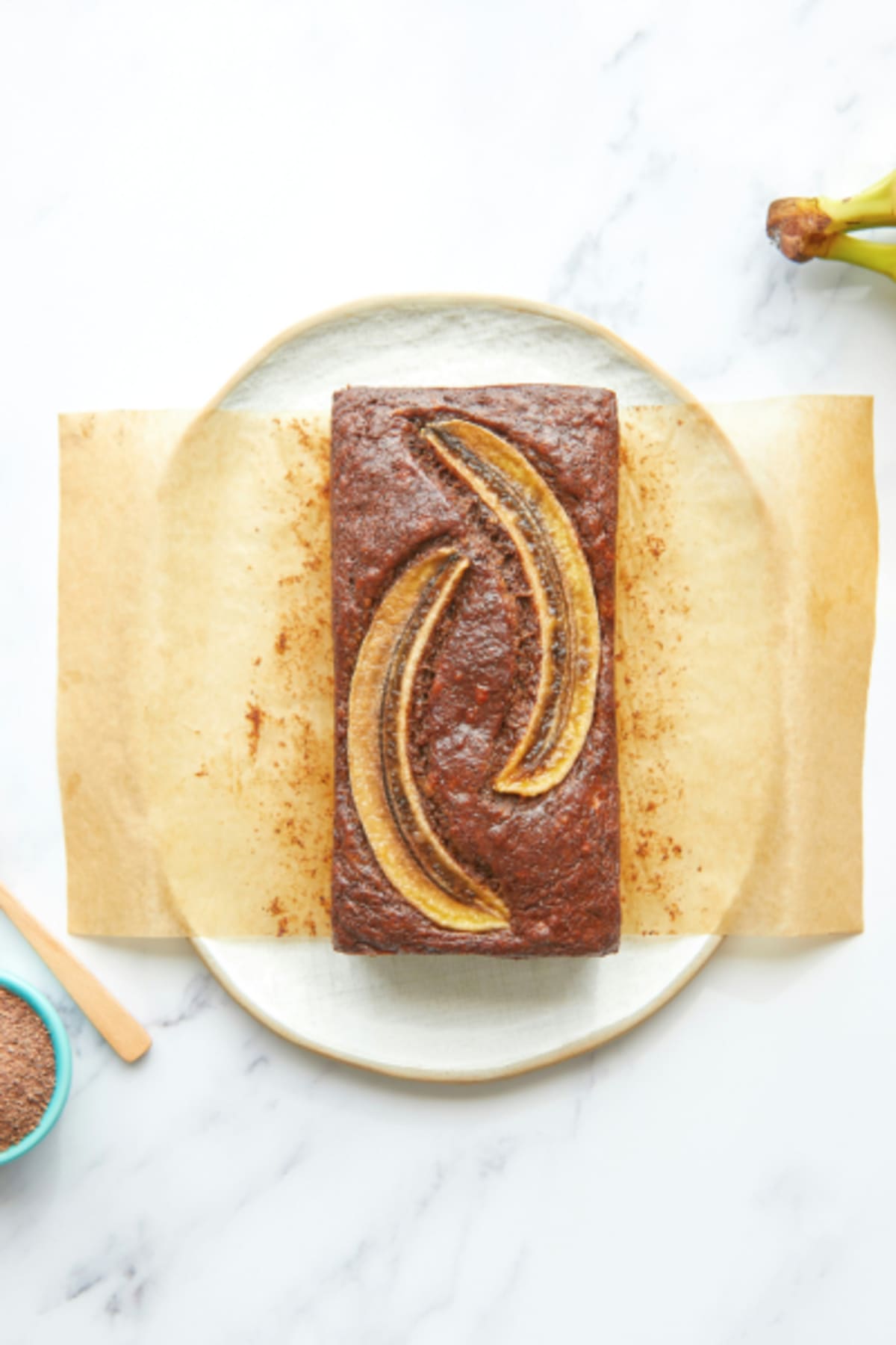 Banana bread au cacao avec deux demi bananes dorées au four sur le dessus