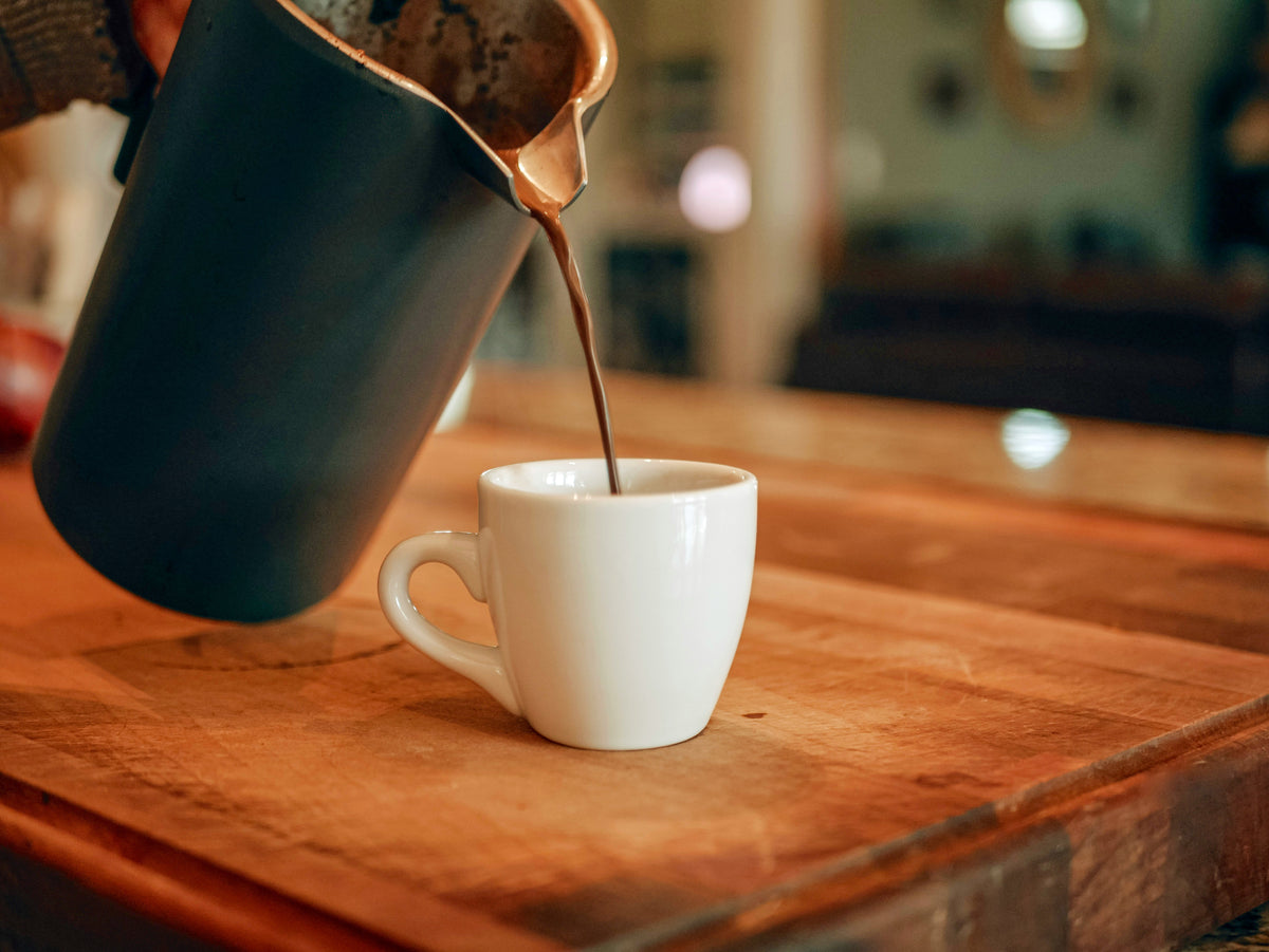 Remplissage d'une tasse de café avec une machine à café à piston sur une table de petit-déjeuner