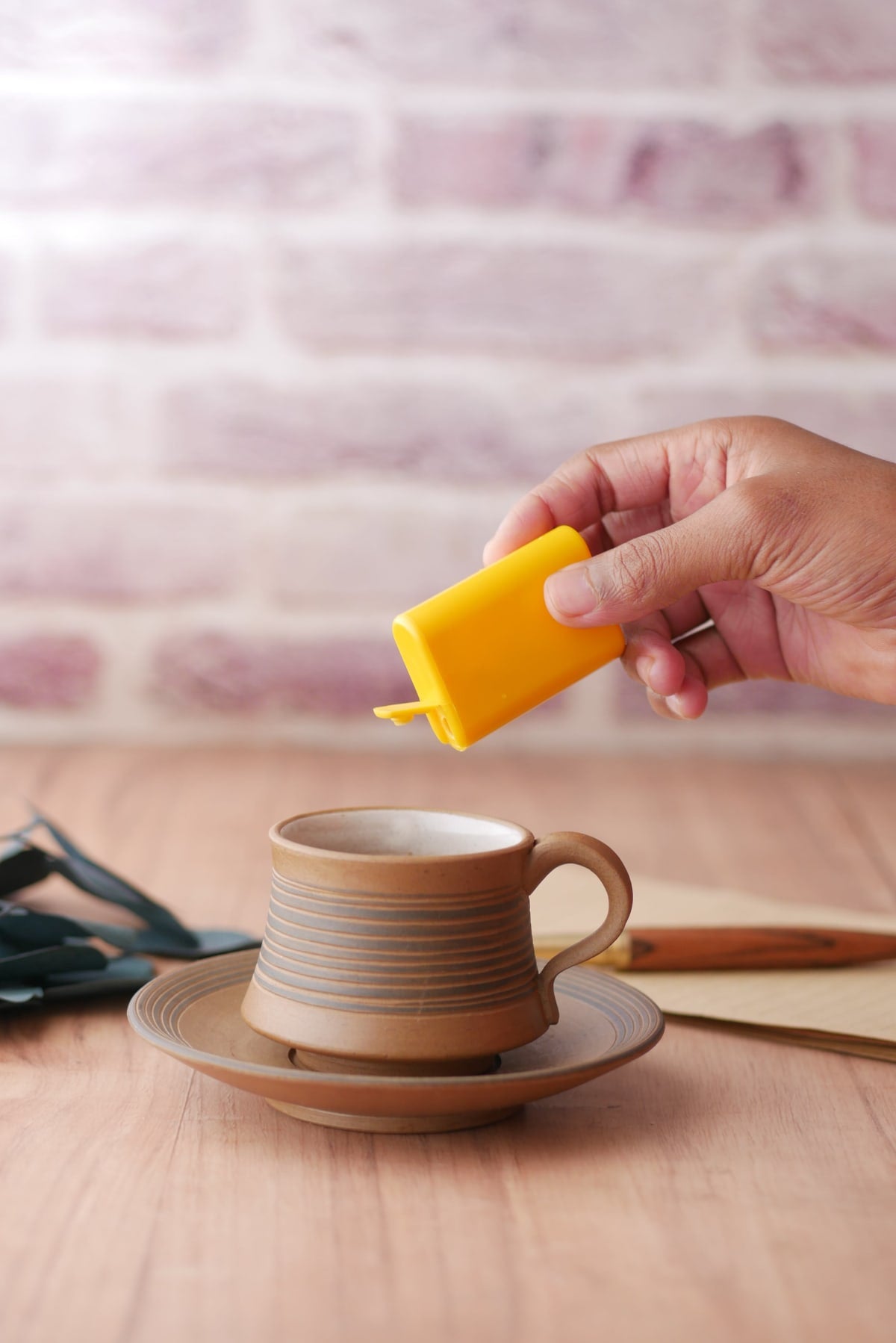 Gros plan sur une boite d'édulcorant naturel et d'une tasse de boisson chaude