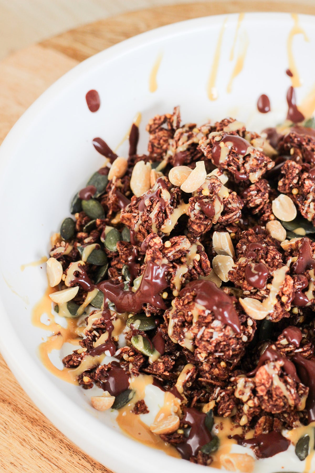 Gros plan sur un granola bowl façon snickers, au chocolat fondu et au caramel