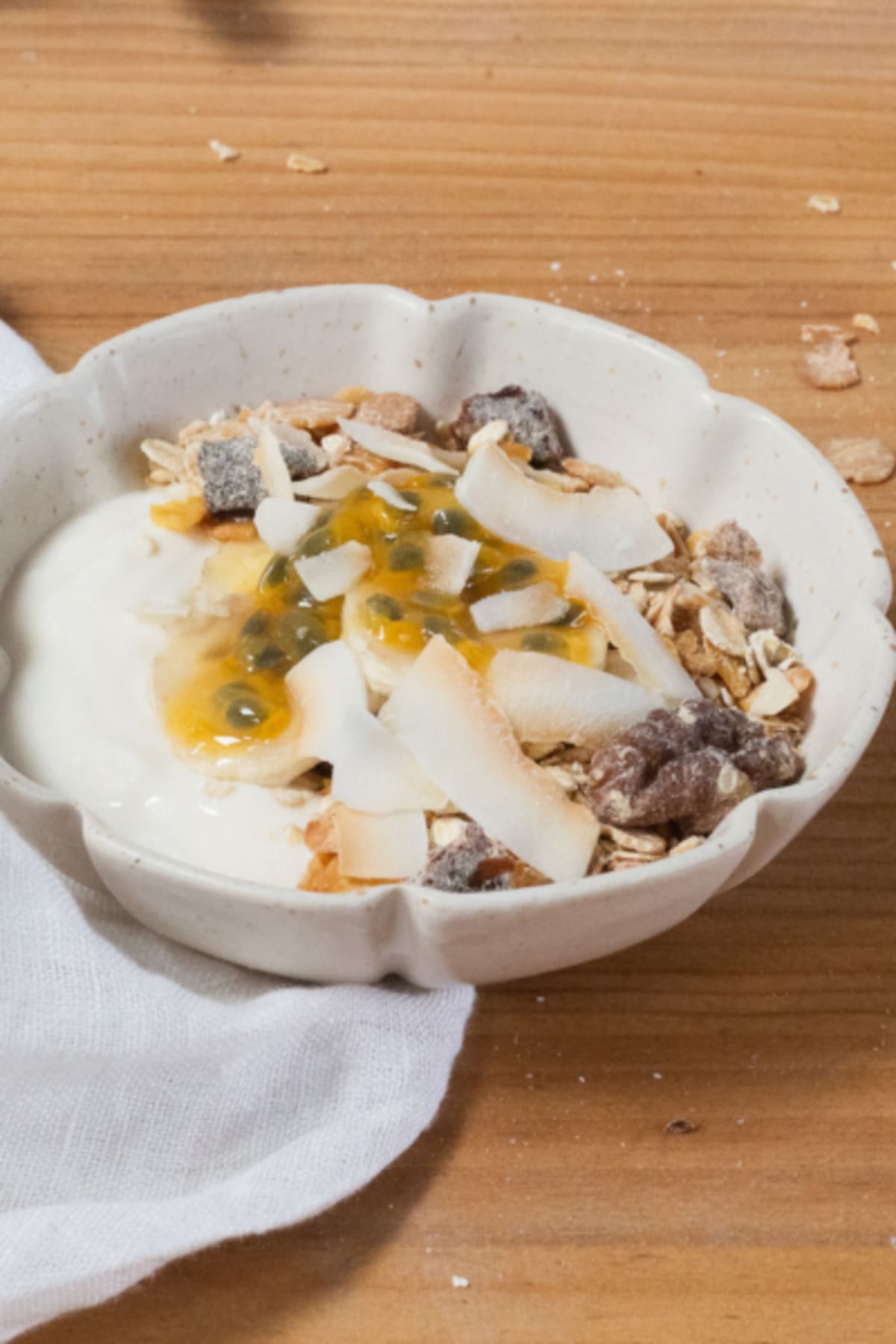 Muesli sur base yaourt avec fruits de la passion, cacahuète et datte séchée dans un bol