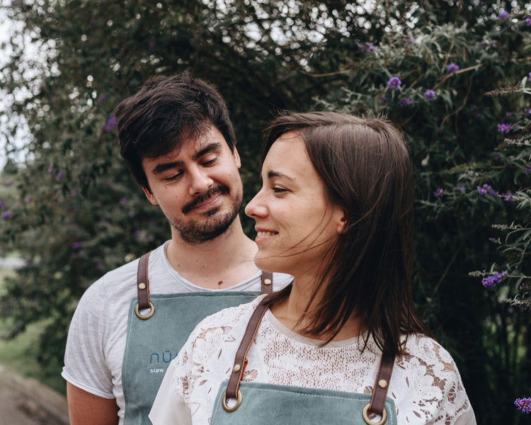 Mathilde et David, fondateurs de nümorning, souriants en extérieur avec leurs tabliers de travail
