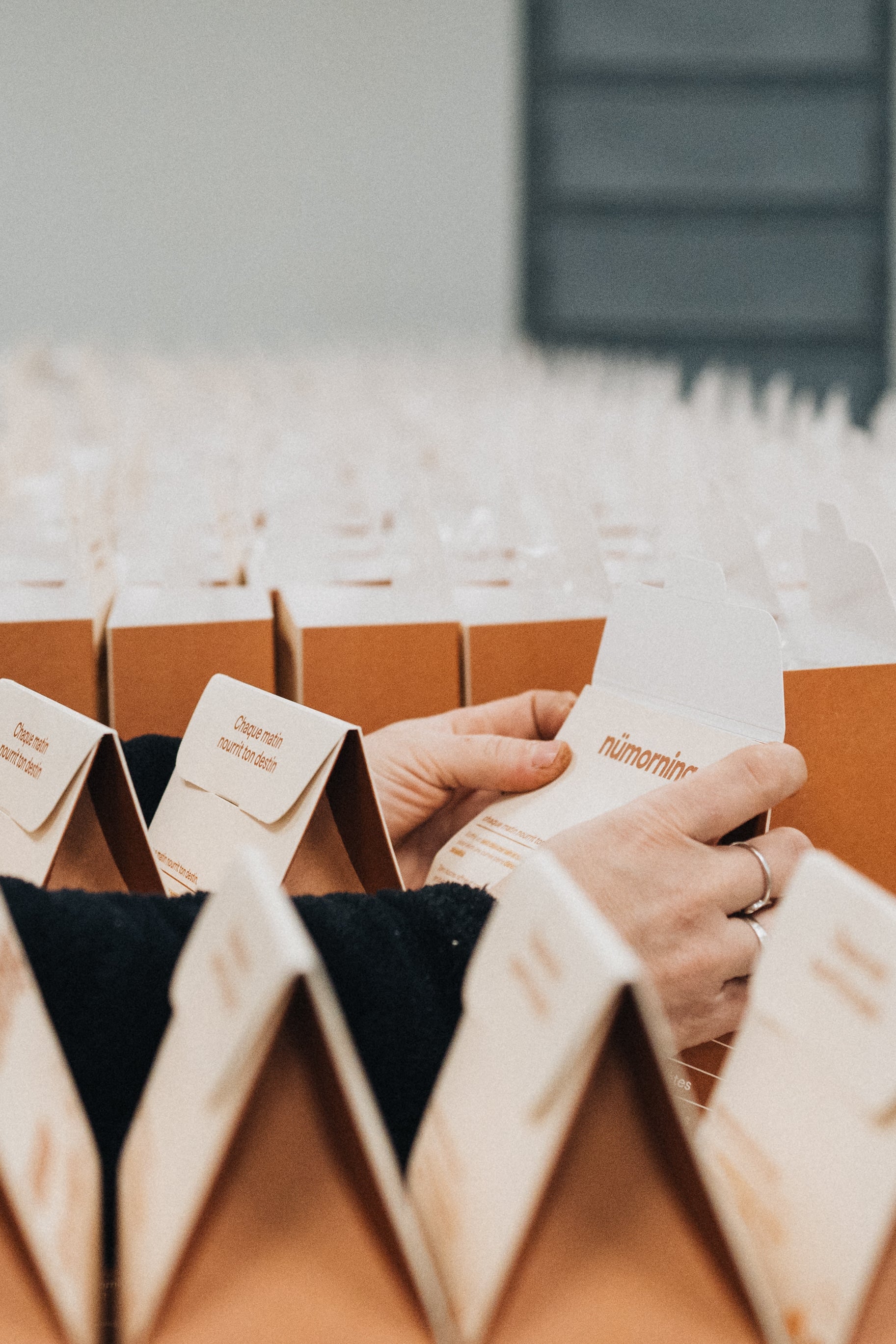 Gros plan sur des mains en train de plier des boîtes nümorning dans l’atelier de fabrication