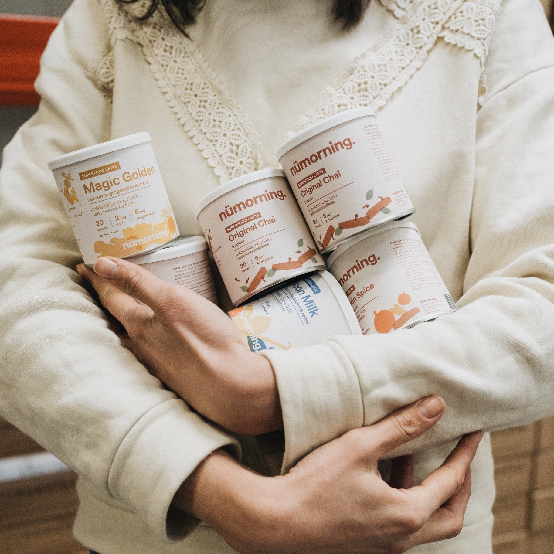 Préparation d’une commande de boissons instantanées bio nümorning avec plusieurs pots dans les bras