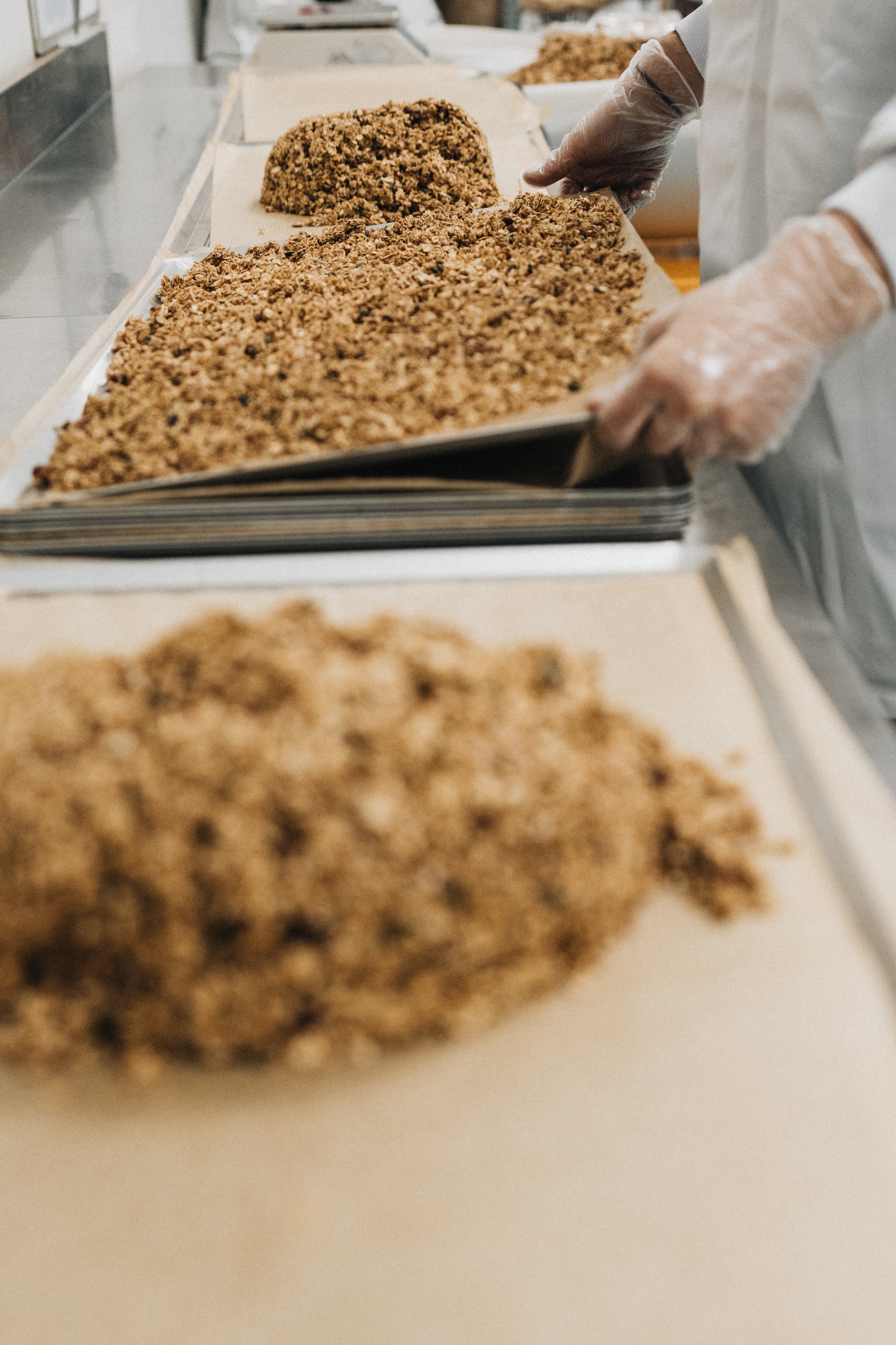 Étape d’étalage du granola maison nümorning sur des plaques avant cuisson