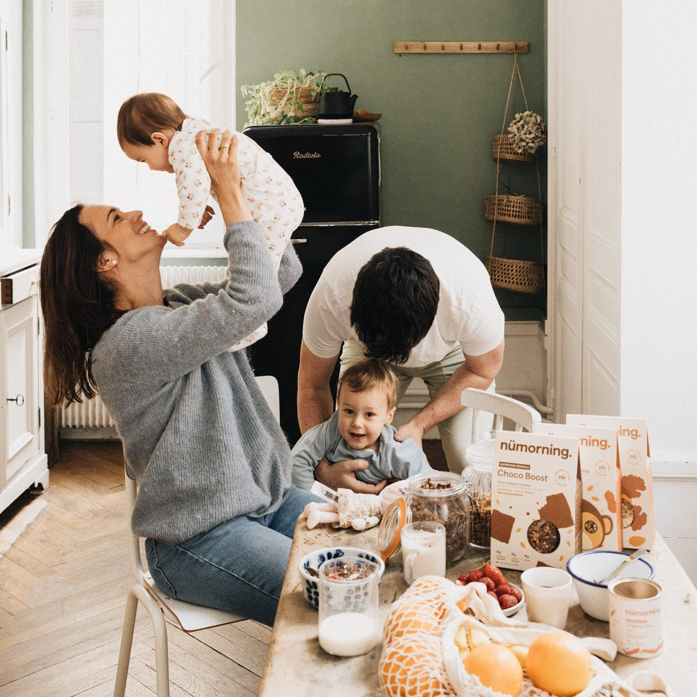 petit-déjeuner en famille, les parents jouant avec leurs enfants.