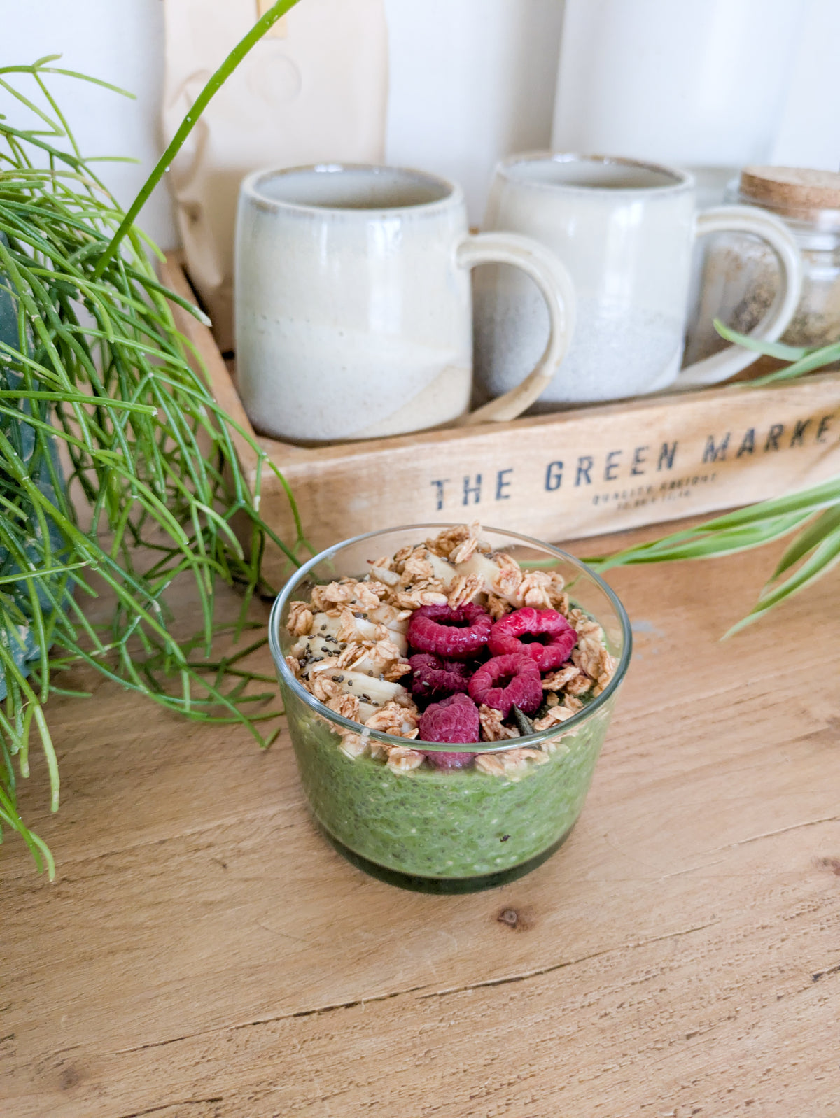 Pudding de chia au matcha avec des framboises, de la banane et du granola