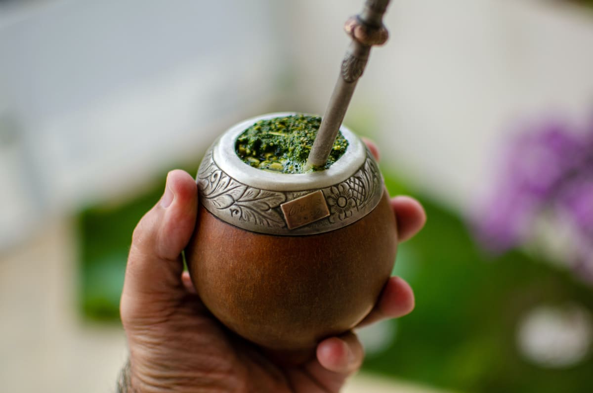 Gros plan sur du yerba maté dans un contenant traditionnel, infusé pour le petit-déjeuner