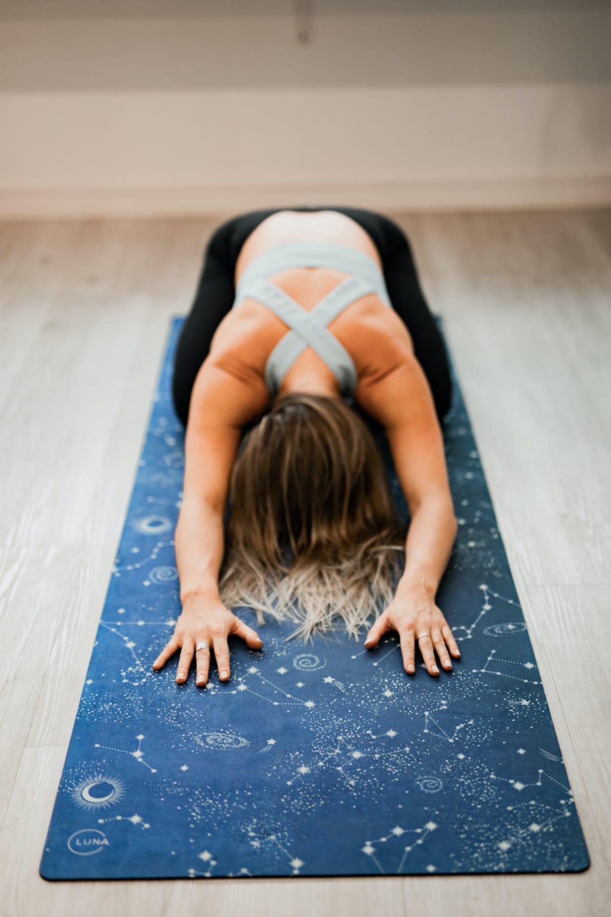 Jeune pratiquante de yoga en posture de l'enfant sur un tapis de yoga
