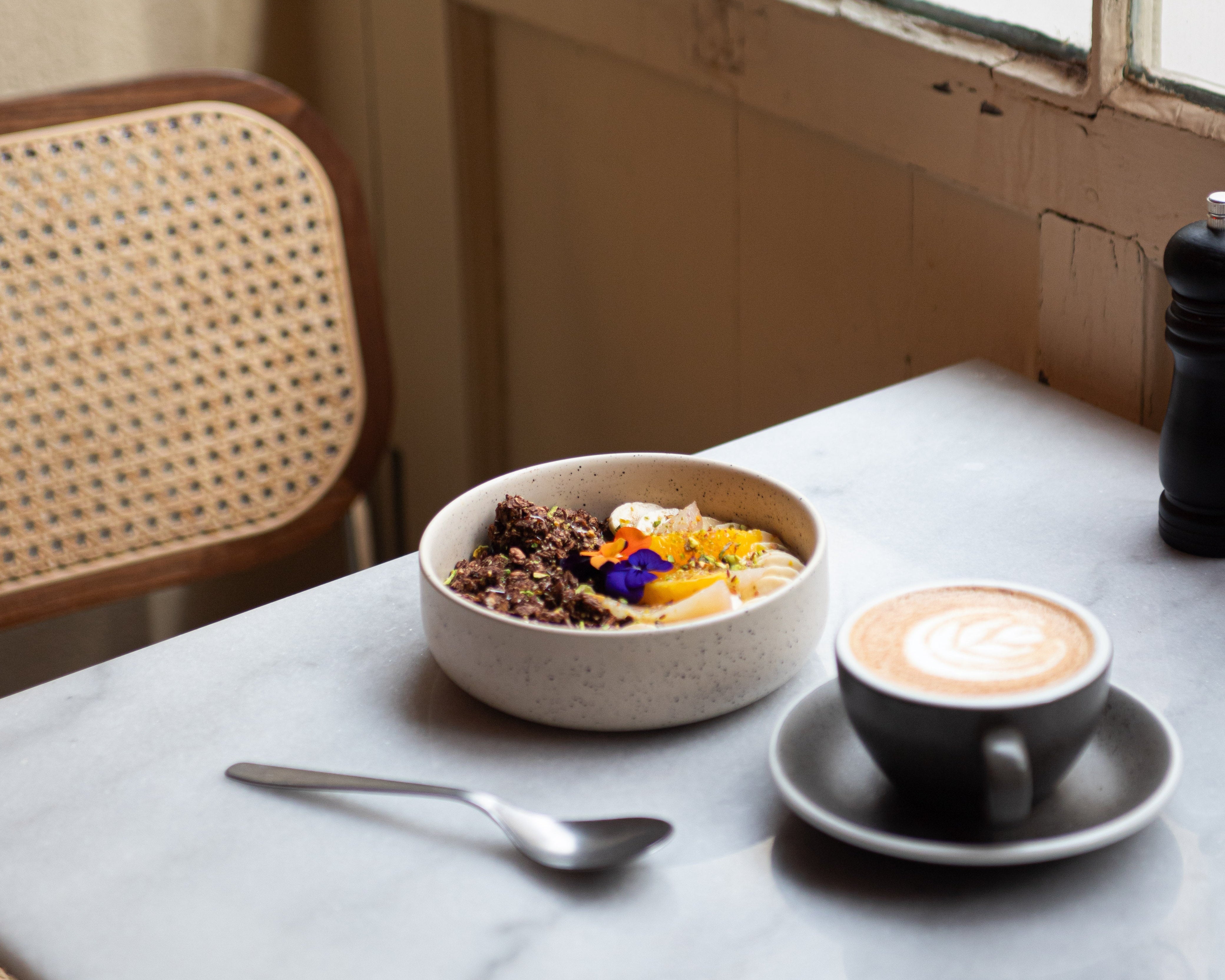 Bol de granola bio au chocolat Choco Boost, de nümorning, avec fruits frais et un café latte