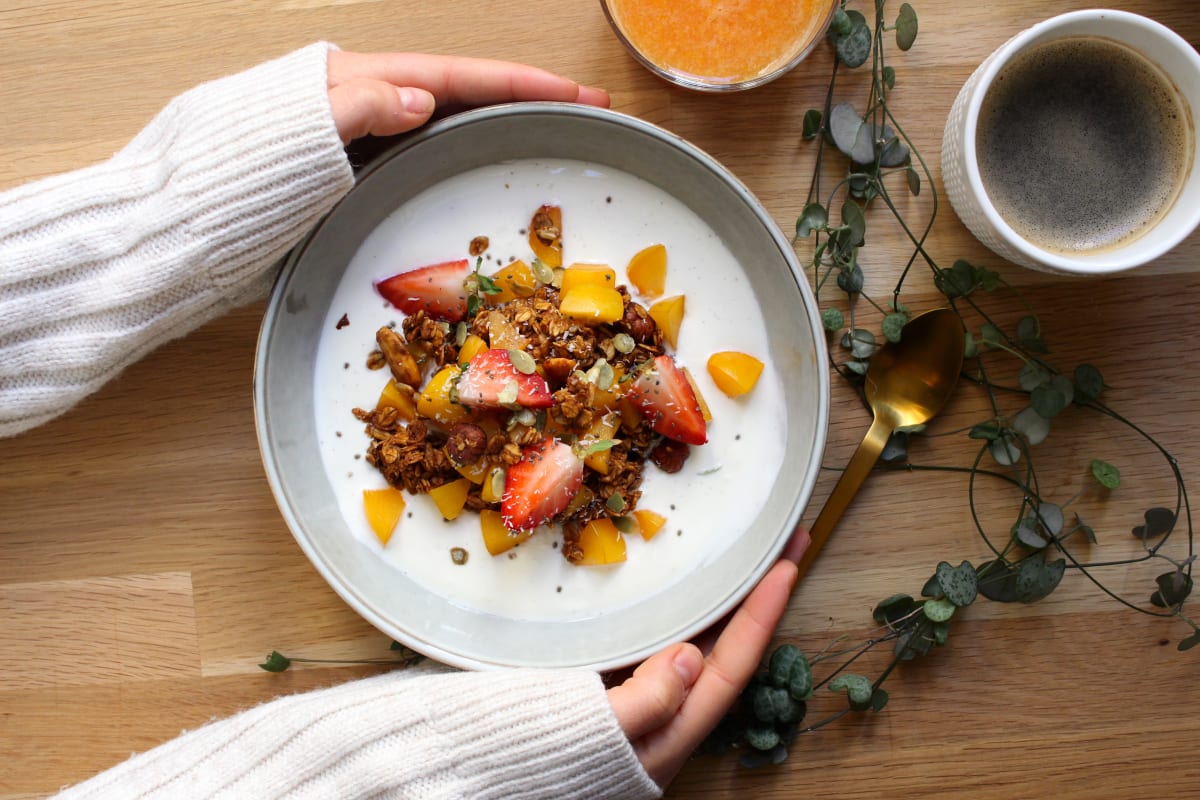 Petit-déjeuner anti-inflammatoire avec granola sur base de yaourt avec fraises, mangue et graines