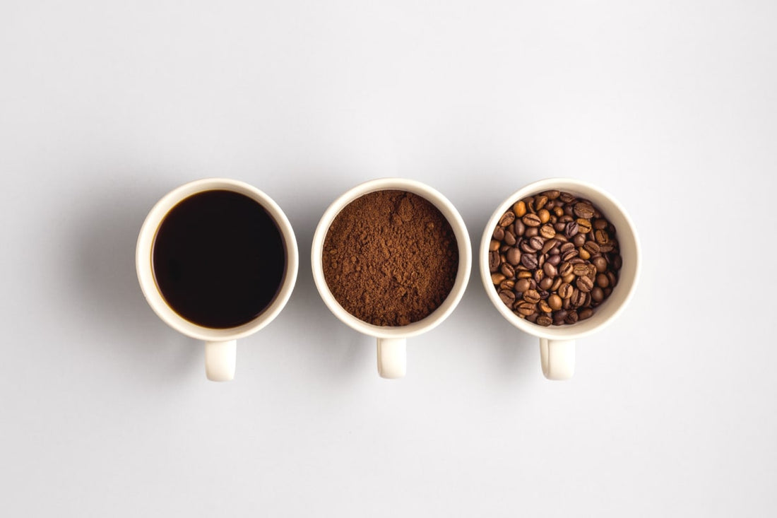 Un mug de grains de cafés, un mug de mouture de café et un mug de café liquide à boire