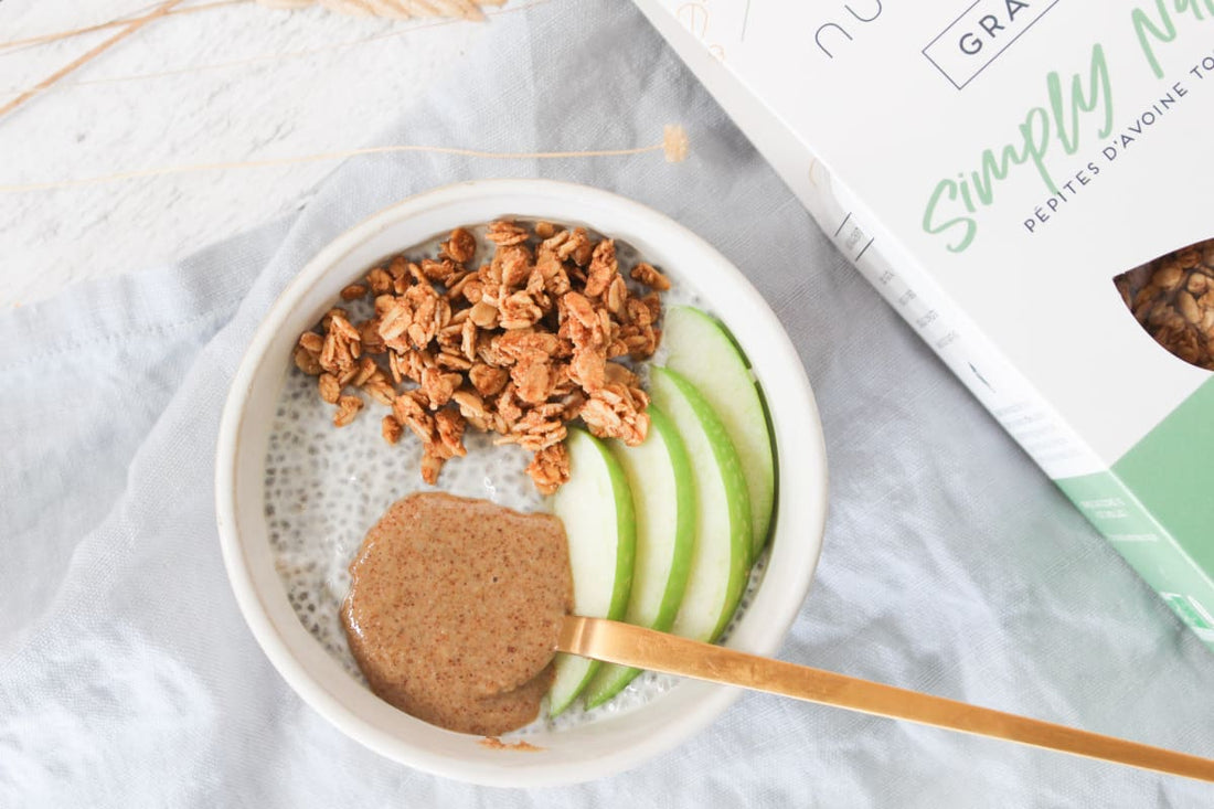 Bol de pudding de chia avec granola, beurre de cacahuète et pomme, sur une table de petit-déjeuner
