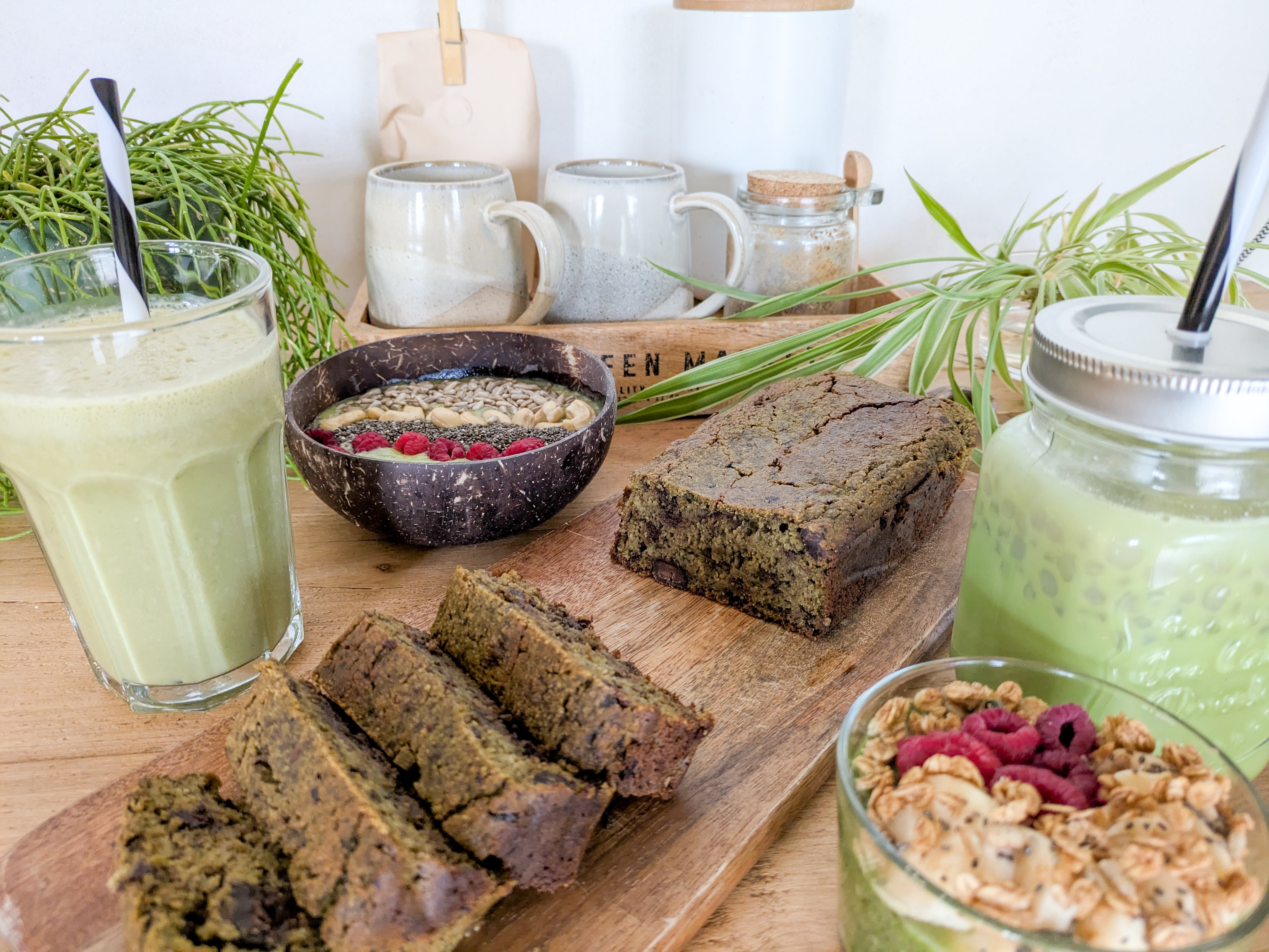 Plusieurs desserts au thé matcha sur une table, comme une smoothie, un gâteau et un pudding de chia