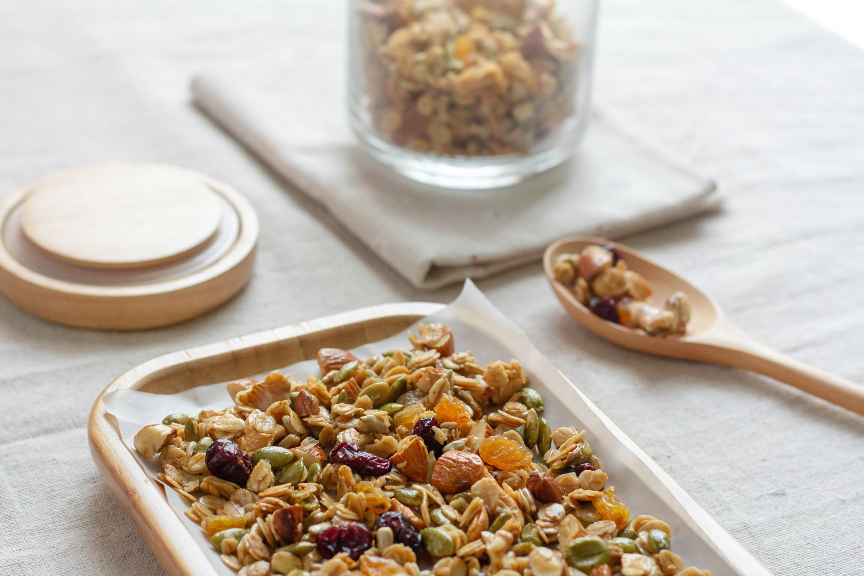 Gros plan sur une plaque de granola maison avec un bocal de granola en fond