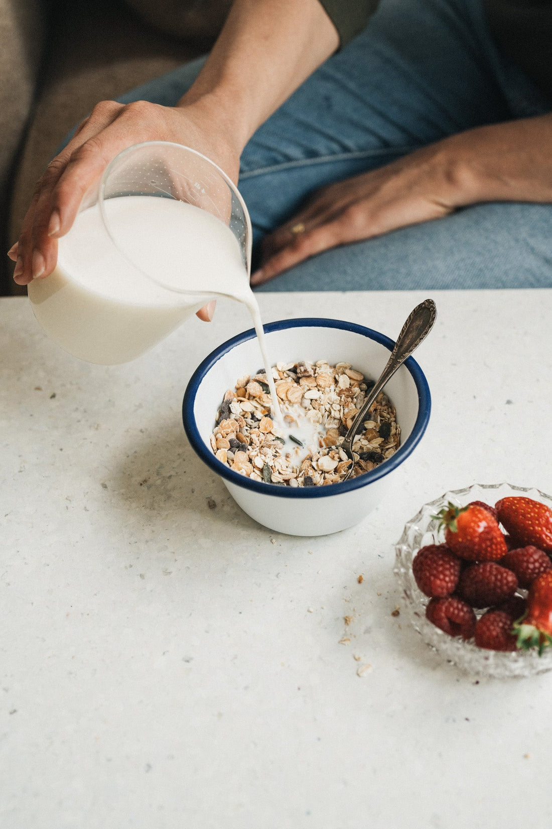 Lait versé dans un bol de muesli protéiné au chocolat.