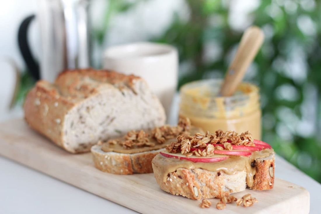Tartine de pain avec pâte à tartiner, tranches de pommes et granola en topping