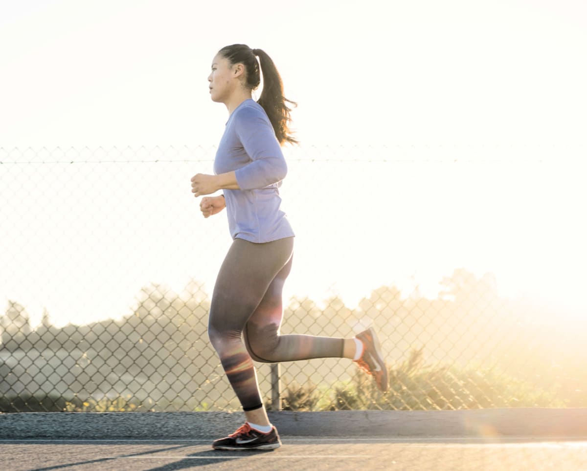 Femme en train de faire de la course à pied en extérieur après son petit-déjeuner Image