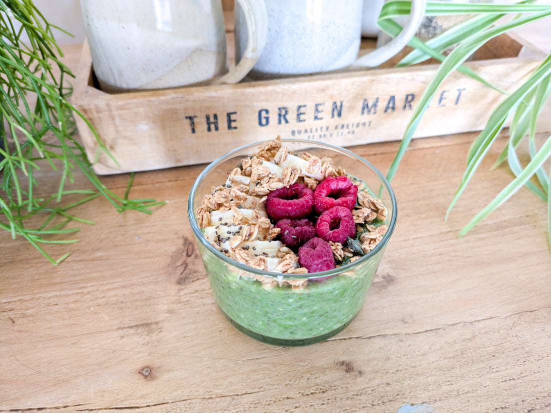 Gros plan sur un pudding de chia au matcha avec framboises, banane, granola et graines de courge