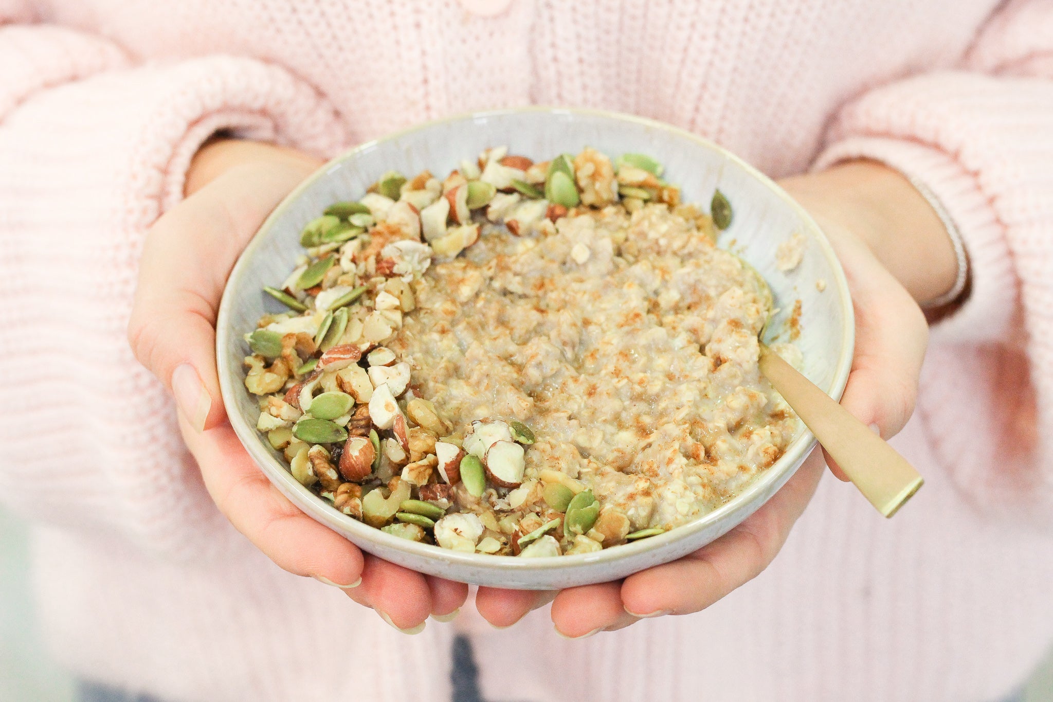Bol de porridge bio onctueux pour le petit-déjeuner, avec éclats d’amandes et graines de courge
