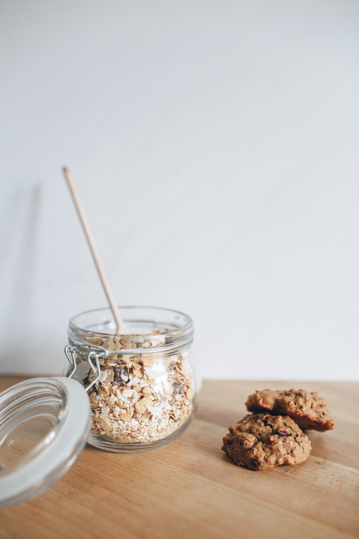 Deux cookies au muesli posés à côté d'un pot de flocons d'avoine