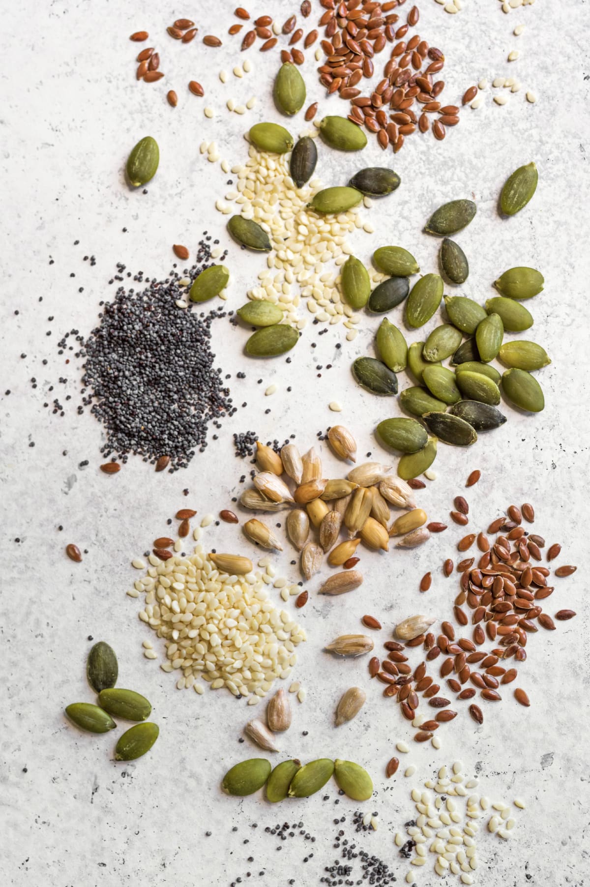 Graines de tournesol, chia, lin, sésame et courge sur une table