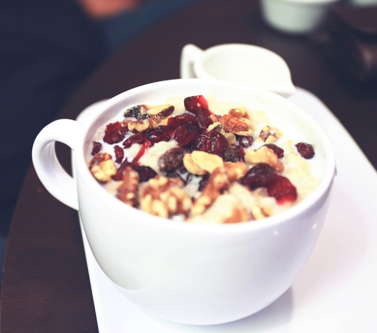 Gros plan sur un overnight porridge crémeux avec des cranberries dans une tasse
