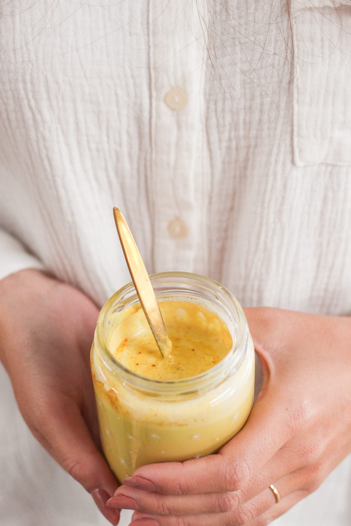Verre de lait d'or maison tenue par une jeune femme