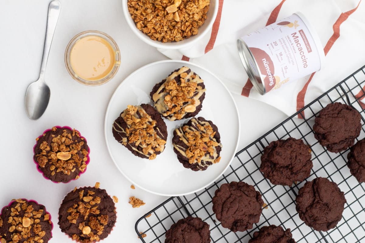 Muffins végans au chocolat avec un filet de beurre de noix et du granola en topping, pour le petit-déjeuner