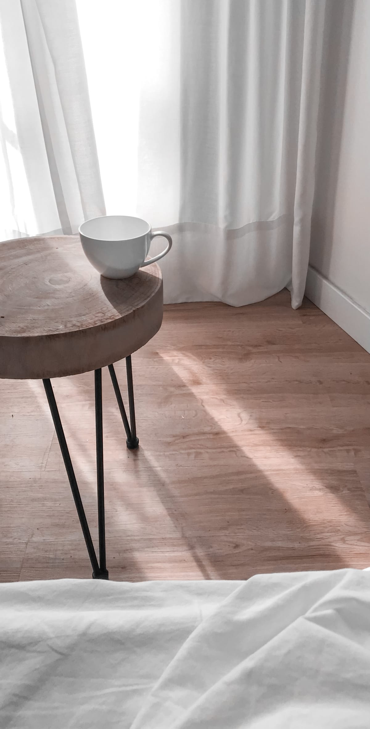 Tasse de café sur une table basse près d'un lit