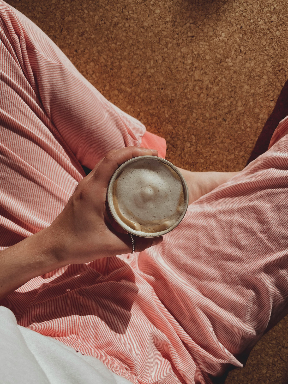 Une femme assise avec une boisson chaude dans un moment de calme, symbole de la routine in &amp; out