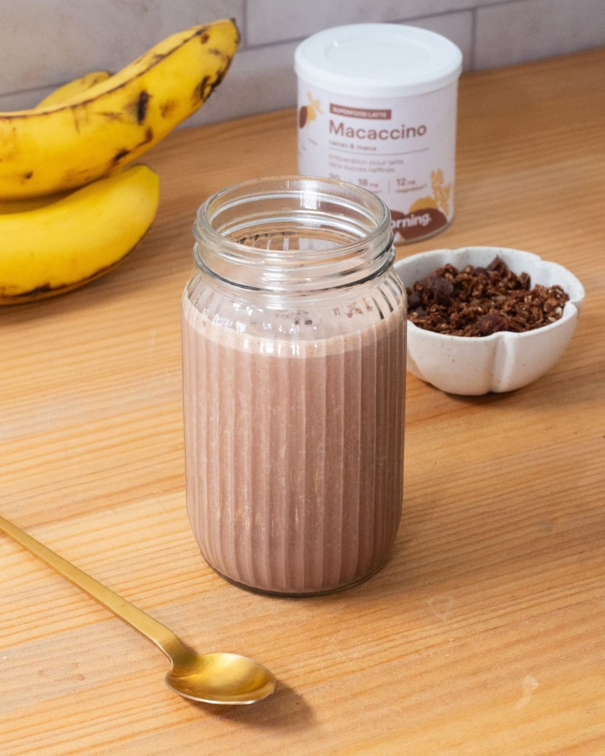 Smoothie végan petit déjeuner au chocolat, avec une grappe de banane et du granola dans un petit bol