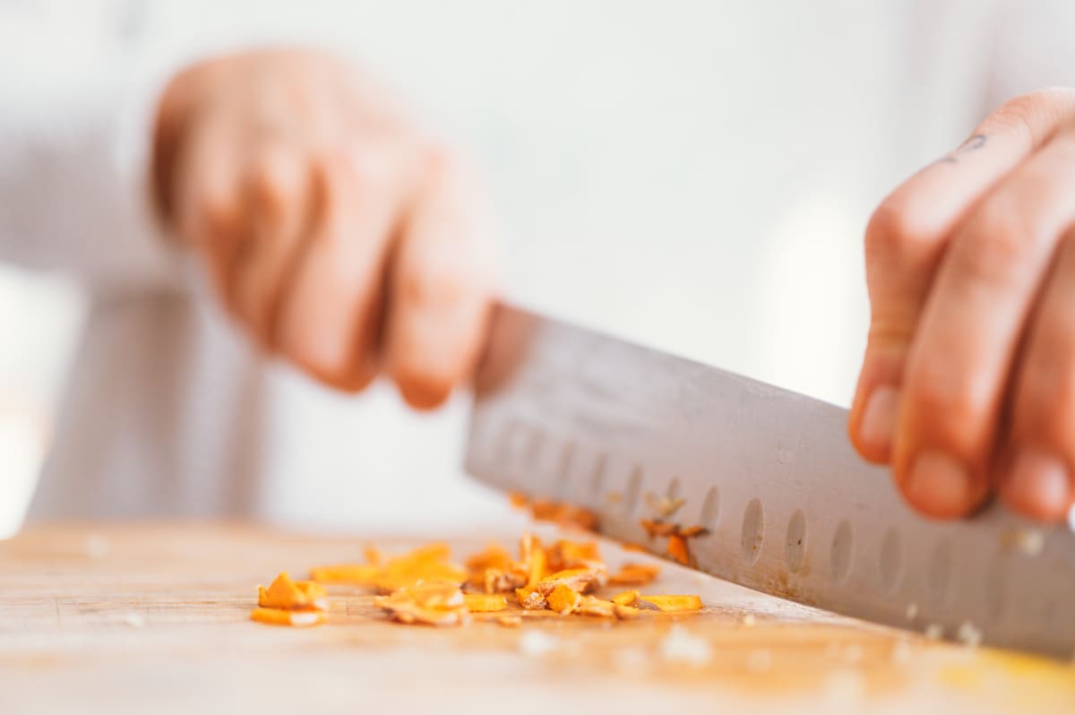 Gros plan sur une planche à découper, un couteau et du curcuma en racine, un aliment anti stress