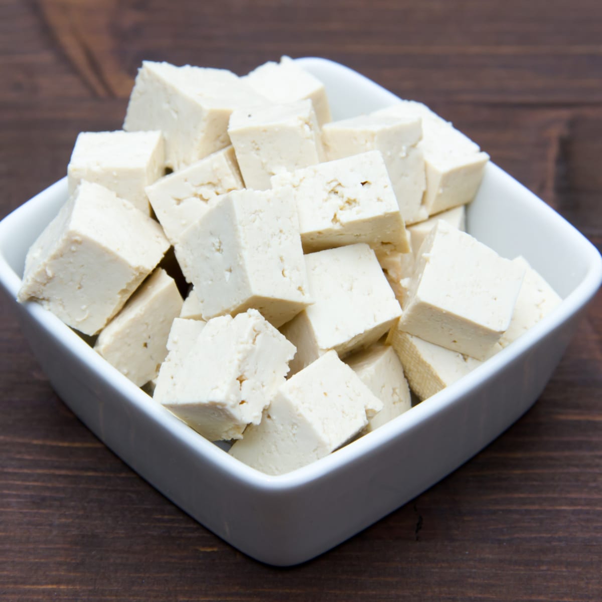 Cubes de tofu dans un petit bol sur une table en bois