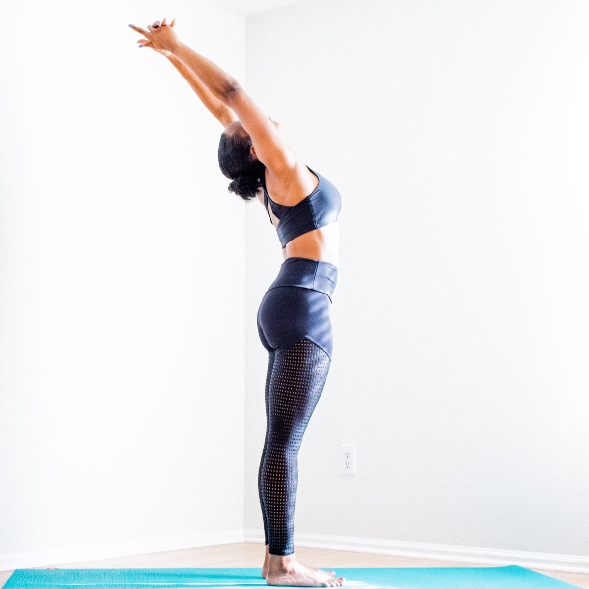 Jeune pratiquante de yoga sur son tapis qui s'étire la colonne vertébrale et travailler son lâcher prise