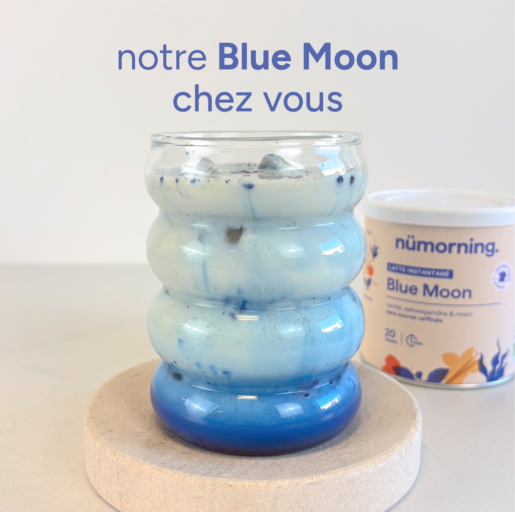 Un blue latte dans un verre, avec un pot de préparation pour blue latte en poudre bio nümorning