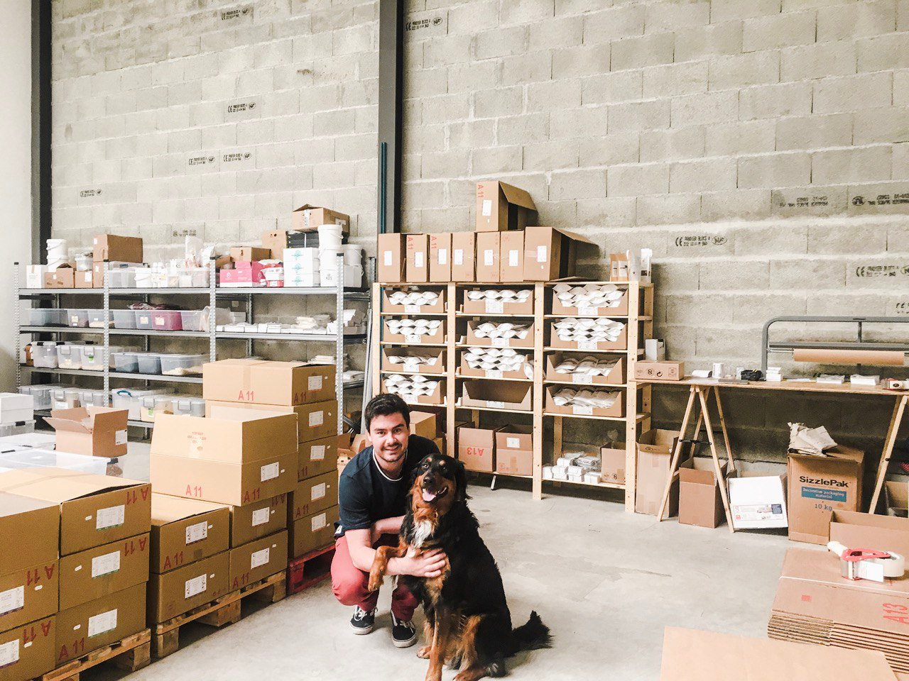 David, cofondateur de nümorning, dans le premier atelier de la marque, entouré de cartons Image
