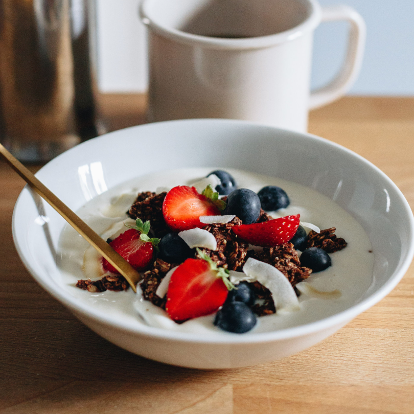 Bol de granola bio au chocolat avec yaourt, fruits rouges et copeaux de coco pour le petit-déjeuner Image