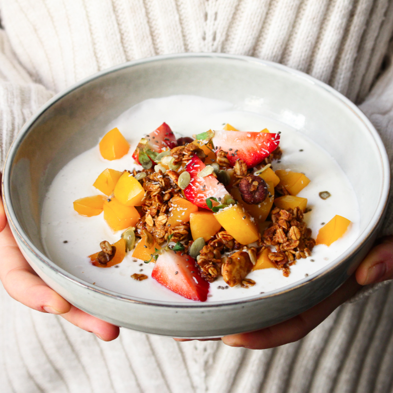 Bol de granola bio nümorning amande, avec yaourt, tranches de fraises et pêche